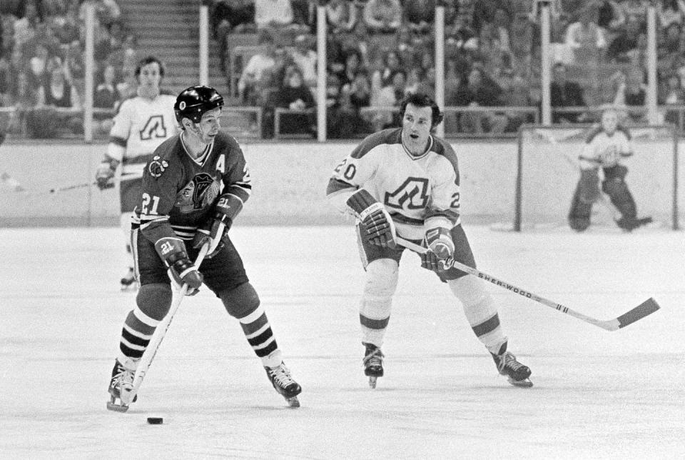 Two hockey players vie for control of the puck.