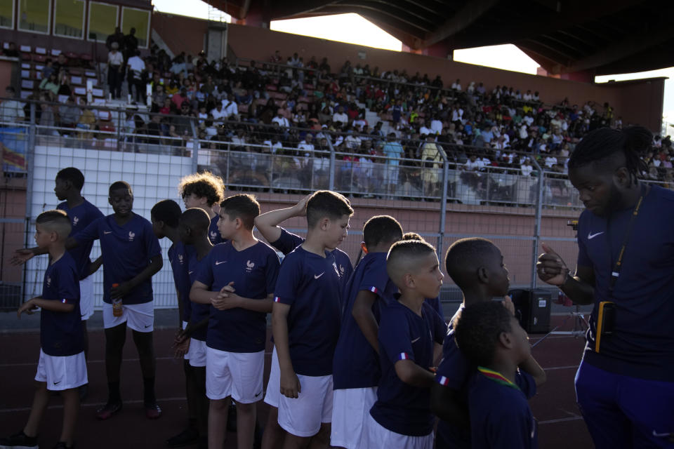 Young fans attend the final game of the national cup of working-class neighborhoods betwwen a team representing players with Malian heritage against one with Congolese roots, in Creteil, outside Paris, France, Saturday, July 2, 2022. This amateur tournament aims to celebrate the diversity of youth from low-income communities with high immigrant populations, areas long stigmatized by some observers and politicians as a breeding ground for crime, riots, and Islamic extremism. (AP Photo/ Christophe Ena)