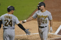 Pittsburgh Pirates' Adam Frazier (26) is greeted by teammate Phillip Evans (24) after scoring off an RBI double by Bryan Reynolds during the third inning of a baseball game against the San Diego Padres, Tuesday, May 4, 2021, in San Diego. (AP Photo/Gregory Bull)