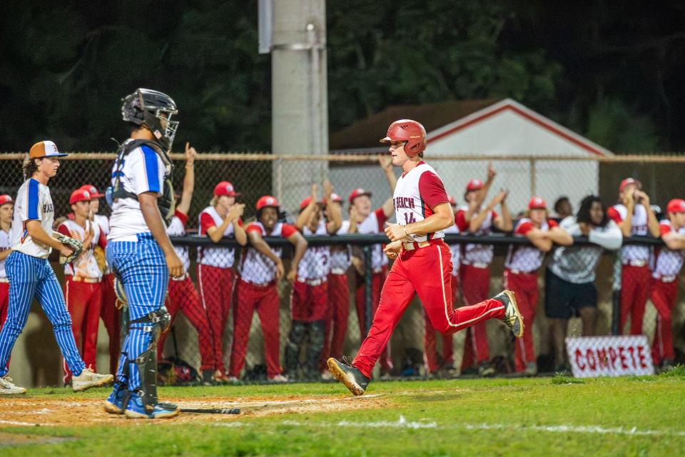 Vero Beach's Cole Morgan (14) scores in front of a cheering dugout in a high school baseball Region 3-7A final against Harmony Monday, May 13, 2024, at Vero Beach High School.