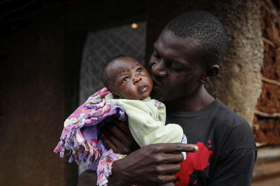 Gabriel Owour Juma holds his daughter Shaniz Joy Juma, delivered a month earlier by a traditional birth attendant during a dusk-to-dawn curfew, in the Kibera slum of Nairobi, Kenya Friday, July 3, 2020. Kenya already had one of the worst maternal mortality rates in the world, and though data are not yet available on the effects of the curfew aimed at curbing the spread of the coronavirus, experts believe the number of women and babies who die in childbirth has increased significantly since it was imposed mid-March. (AP Photo/Brian Inganga)