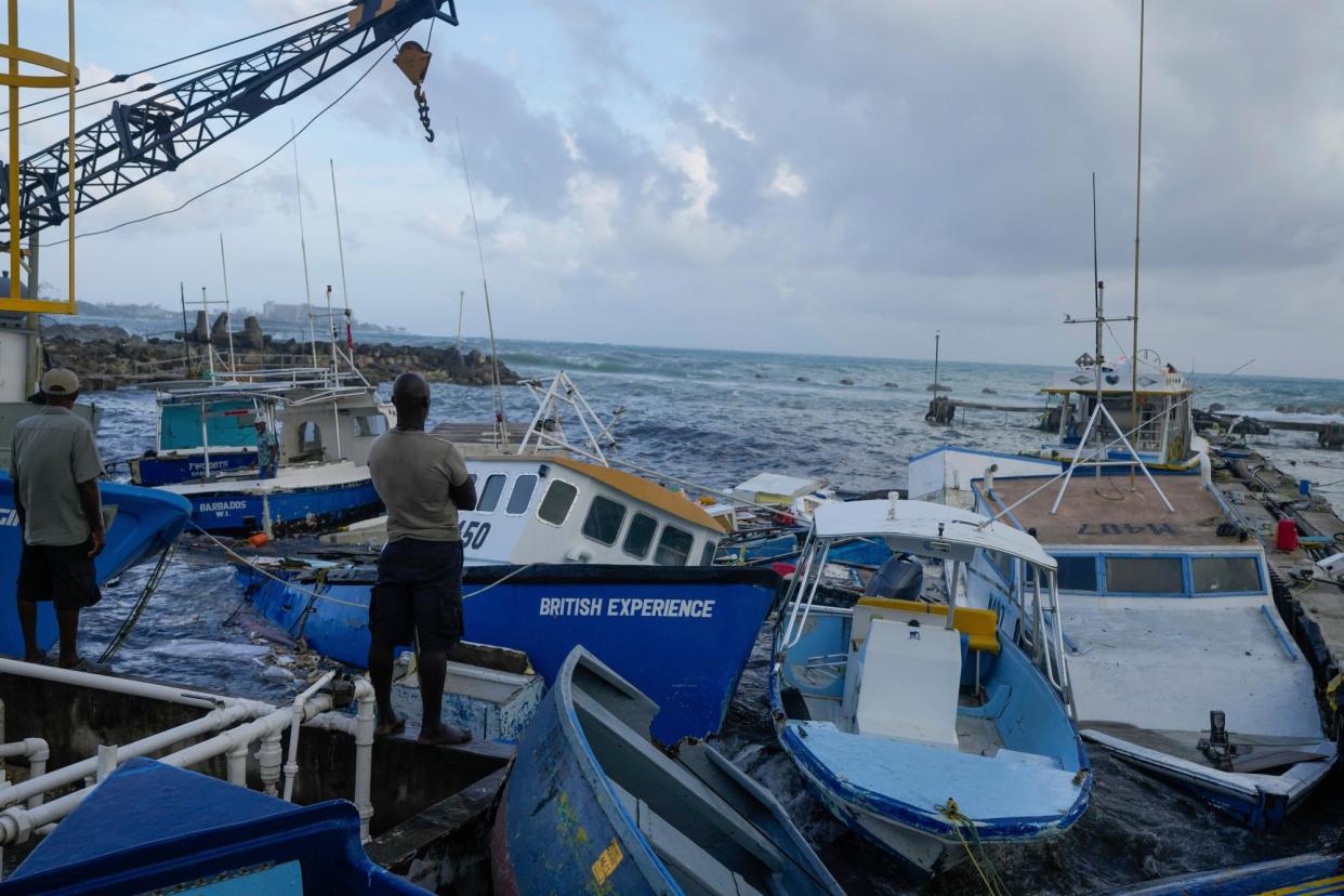 <span>Fishermen look out at vessels damaged by Hurricane Beryl in Barbados on 1 July 2024.</span><span>Photograph: Ricardo Mazalán/AP</span>