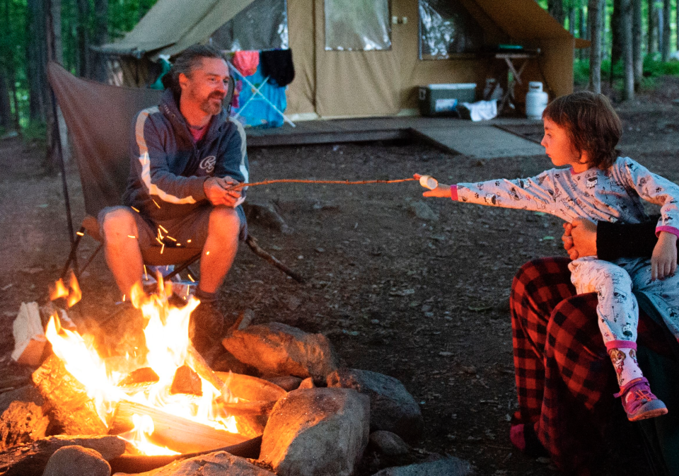 A family enjoys a campfire at the Huttopia Sutton glamping ground in Quebec, Canada, on August 14, 2019. (Photo: SEBASTIEN ST-JEAN/AFP via Getty Images)