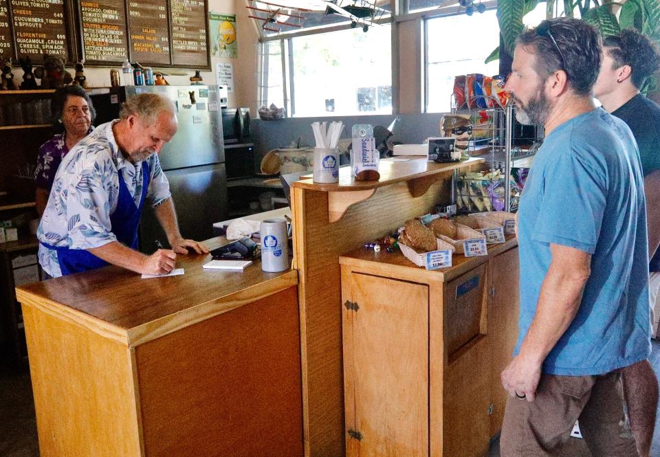Sandy and Pat Watson of the Sandwichery, left, take a sandwich order from Owen Scott and his son Jasper before they go on a fishing expedition to Whiskeytown on Thursday, Sept. 22, 2022. Scott parked around the corner where parking is at a premium in downtown Redding.