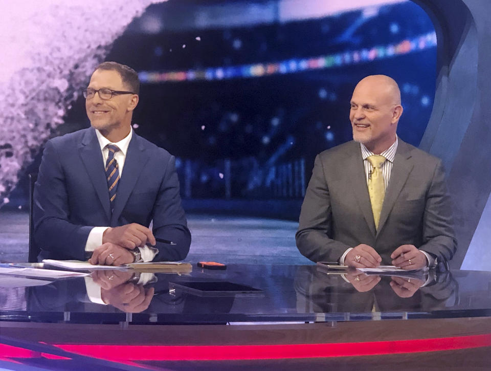 Former New Jersey Devils defensemen Scott Stevens, left, and Ken Daneyko appear on the set of NHL Network in Secaucus, N.J., Monday, April 29, 2019. After teaming up to help the New Jersey Devils win the Stanley Cup three times, retired defensemen Scott Stevens and Ken Daneyko are back together on the other side of the camera doing TV at NHL Network. After developing on-ice chemistry over 12 years, doing it on the air is a new challenge. (AP Photo/Stephen Whyno)