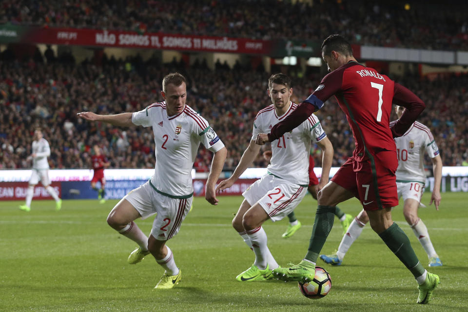 Portugal's Cristiano Ronaldo, right, duels for the ball with, from left, Hungary's Adam Lang, Hungary's Barnabas Bese, and Hungary's Zoltan Gera during the World Cup Group B qualifying soccer match between Portugal and Hungary at the Luz stadium in Lisbon Saturday, March 25 2017. (AP Photo/Armando Franca)