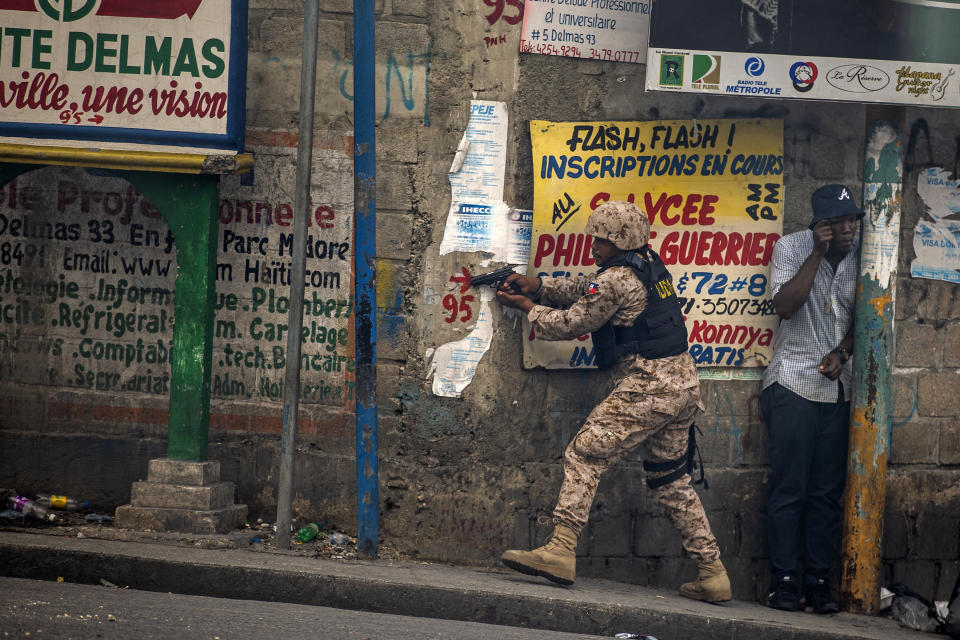 A police officer points his gun at residents of Delmas 95 district during a protest demanding the resignation of Haiti's president Jovenel Moise in Port-au-Prince, Haiti, Nov. 18, 2019. The image was part of a series of photographs by Associated Press photographers which was named a finalist for the 2020 Pulitzer Prize for Breaking News Photography. (AP Photo/Dieu Nalio Chery)