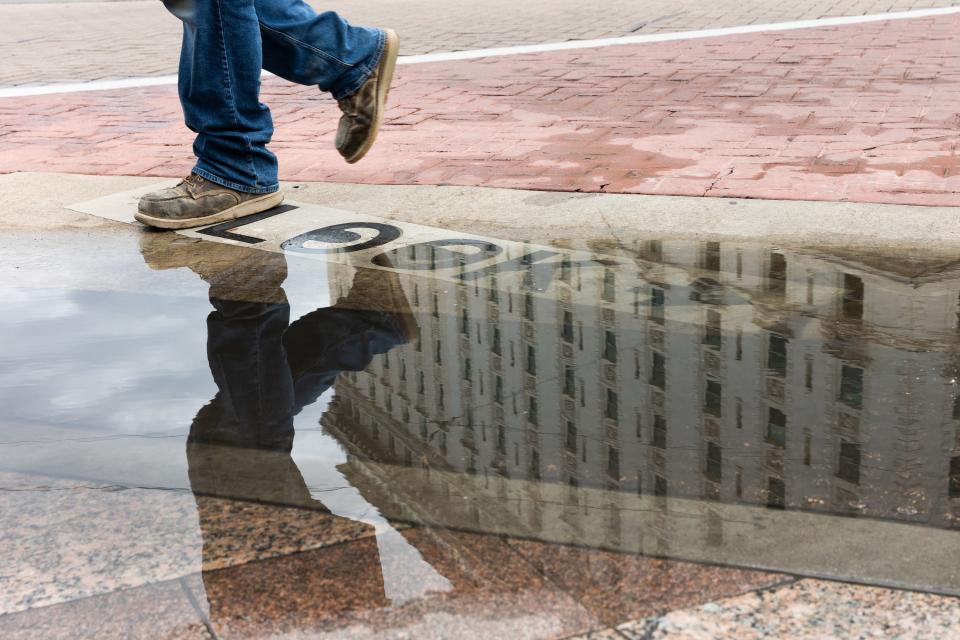 A puddle left by the rain reflects someone walking in downtown Salt Lake City on Tuesday, Aug. 22, 2023. | Megan Nielsen, Deseret News