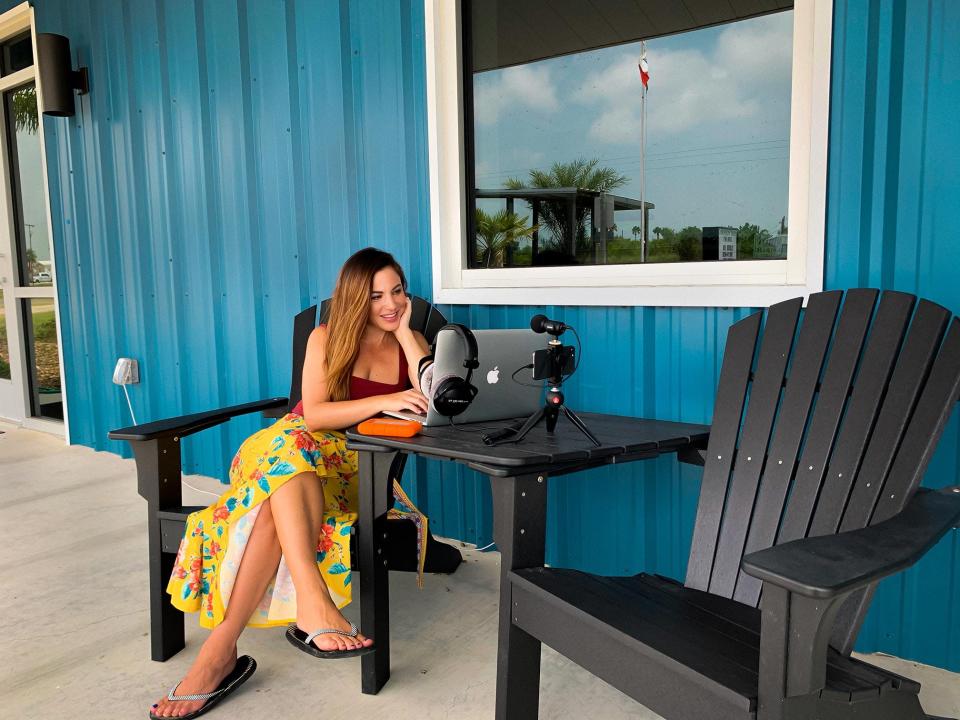 Julin Jean uses the chairs and desk outside the closed Port O'Connor Texas public library to get a WiFi signal and work during the pandemic