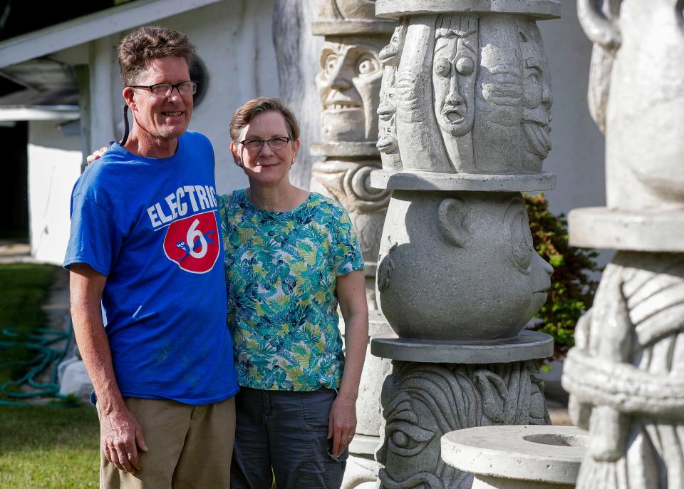 Eric and Molly Gunderson stand beside one of their sculpted totem poles on Monday, July 11, 2022, at their home on Highway 52 near Aniwa, Wis. The couple are both artists, and their work can be found throughout their home and property.