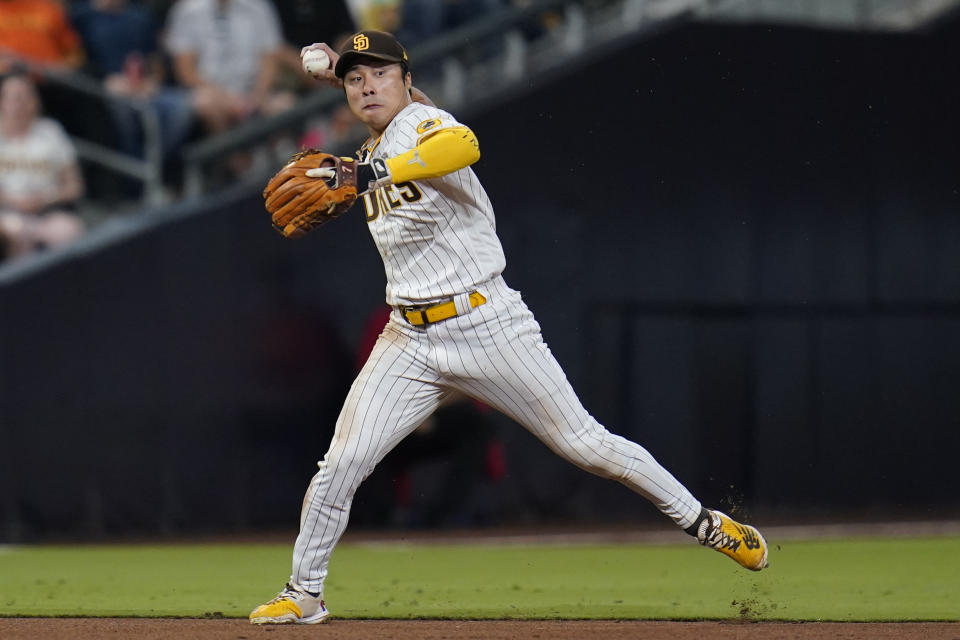 San Diego Padres shortstop Ha-Seong Kim throws to first too late as Washington Nationals' Lane Thomas singled during the eighth inning of a baseball game Thursday, Aug. 18, 2022, in San Diego. (AP Photo/Gregory Bull)