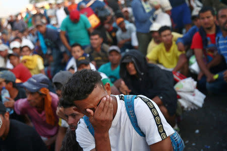 Un migrante centroamericano, parte de una caravana que intenta llegar a Estados Unidos, gesticula mientras espera en el puente que une México y Guatemala para cruzar a México para continuar su viaje, en Ciudad Hidalgo, México, 22 de octubre de 2018. REUTERS/Edgard Garrido