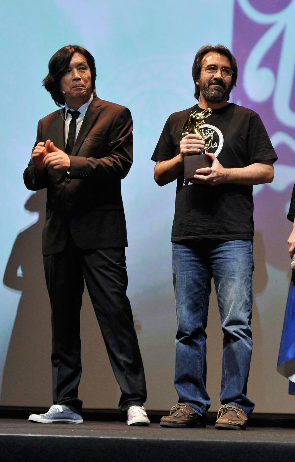 DUBAI, UNITED ARAB EMIRATES - DECEMBER 16: Producer Zeki Demirkubuz (R) with the Muhr AsiaAfrica Feature Best Film award during the Closing Ceremony on day eight of the 9th Annual Dubai International Film Festival held at the Madinat Jumeriah Complex on December 16, 2012 in Dubai, United Arab Emirates. (Photo by Gareth Cattermole/Getty Images for DIFF)