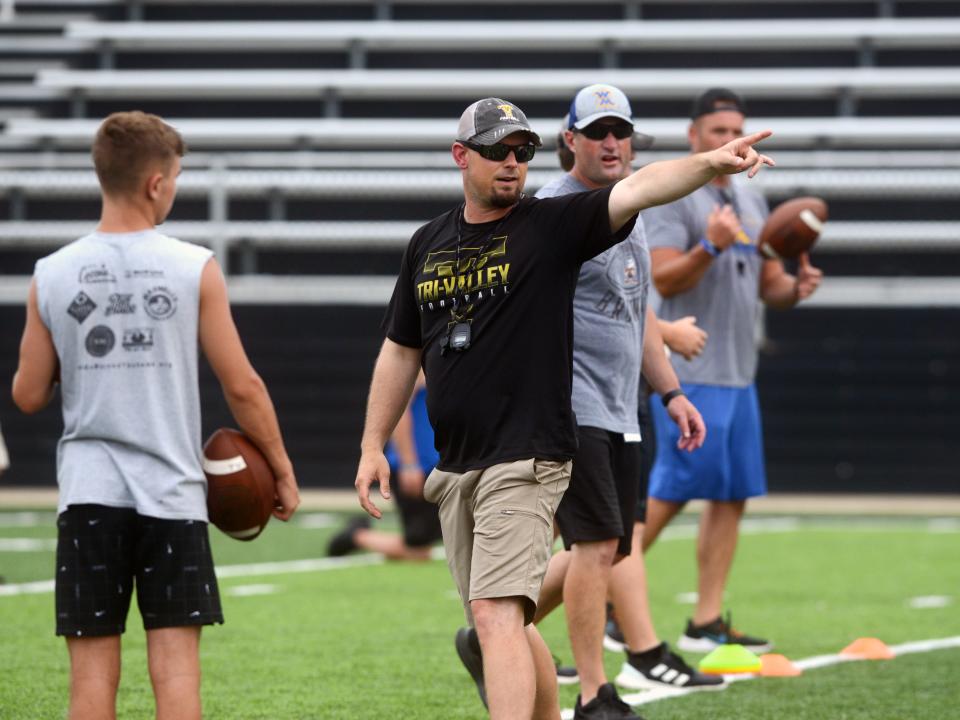 Head coach Cameron West, from Tri-Valley, talks to the quarterbacks and running backs iduring a drill in Muskingum Valley League All-Star practice on Monday at Tri-Valley's Jack Anderson Stadium in Dresden.