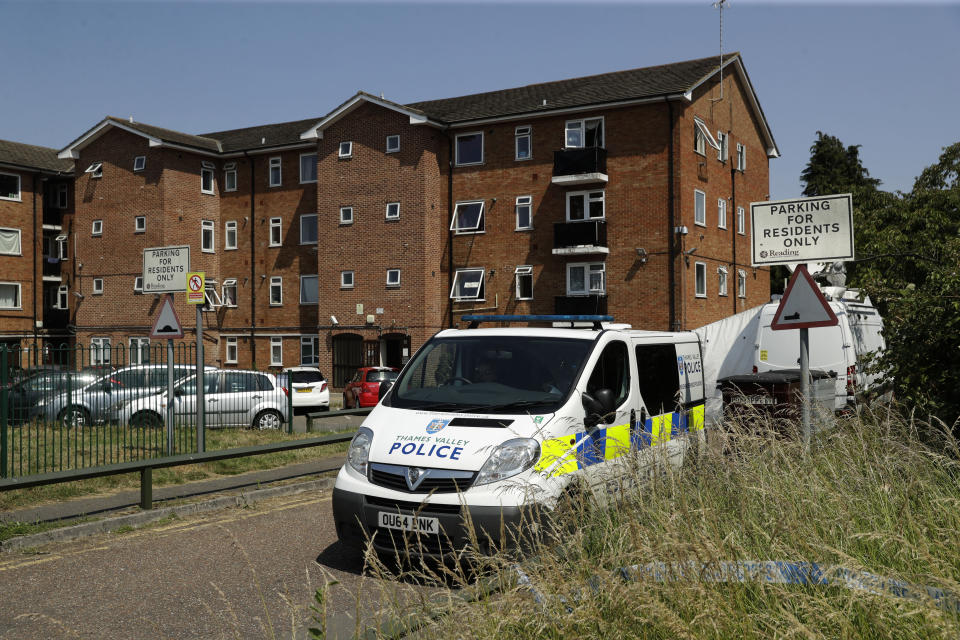 A police van sits parked outside a building where a flat was being searched after a fatal multiple stabbing attack in Forbury Gardens park, in Reading, England, Tuesday, June 23, 2020. The English town of Reading is mourning for three people stabbed to death on Saturday in what is being treated as a terror attack. (AP Photo/Matt Dunham)