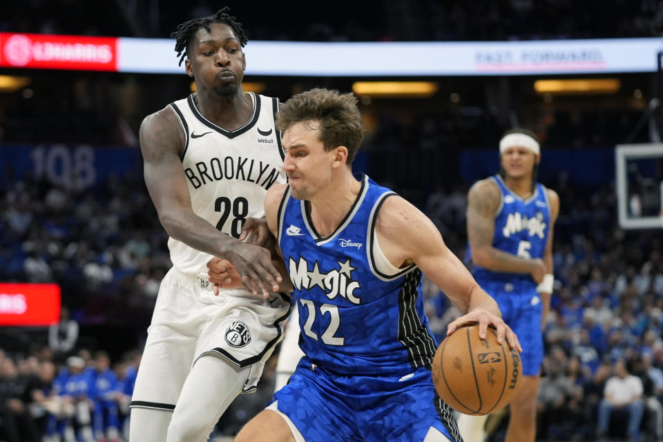 Orlando Magic forward Franz Wagner (22) pushes past Brooklyn Nets forward Dorian Finney-Smith (28) as he attempts to get to the basket during the second half of an NBA basketball game Wednesday, March 13, 2024, in Orlando, Fla. (AP Photo/John Raoux)