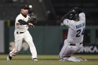 San Francisco Giants second baseman Tommy La Stella, left, throws to first base after forcing out Miami Marlins' Jesus Aguilar (24) at second base on a double play hit into by Adam Duvall during the seventh inning of a baseball game in San Francisco, Thursday, April 22, 2021. (AP Photo/Jeff Chiu)