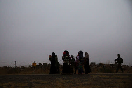 Syrians walk to a bus just after they crossed the armistice line from Syria to the Israeli-occupied Golan Heights to get medical treatment in Israel, July 11, 2018. REUTERS/ Ronen Zvulun