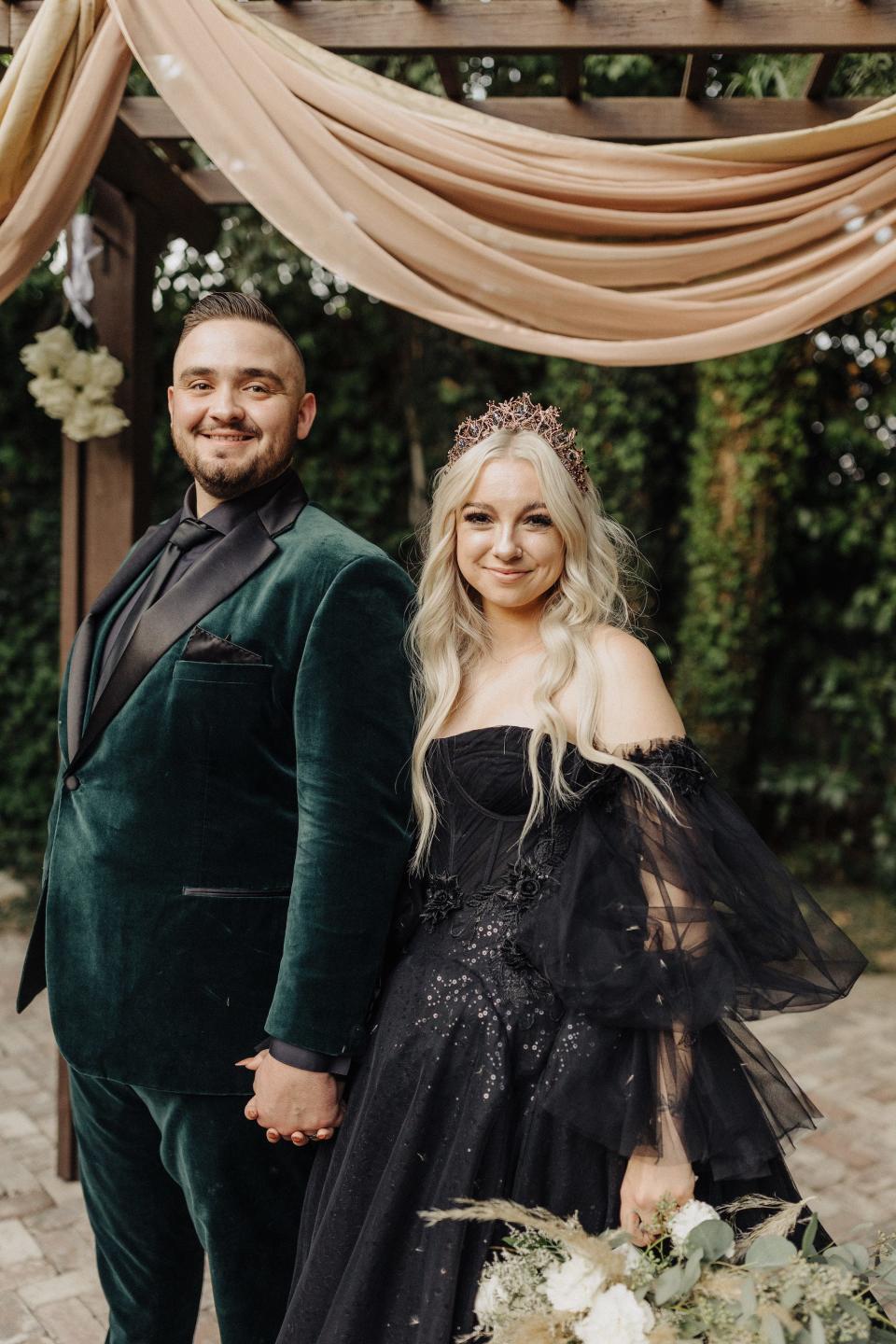 A bride and groom hold hands in front of their wedding altar.