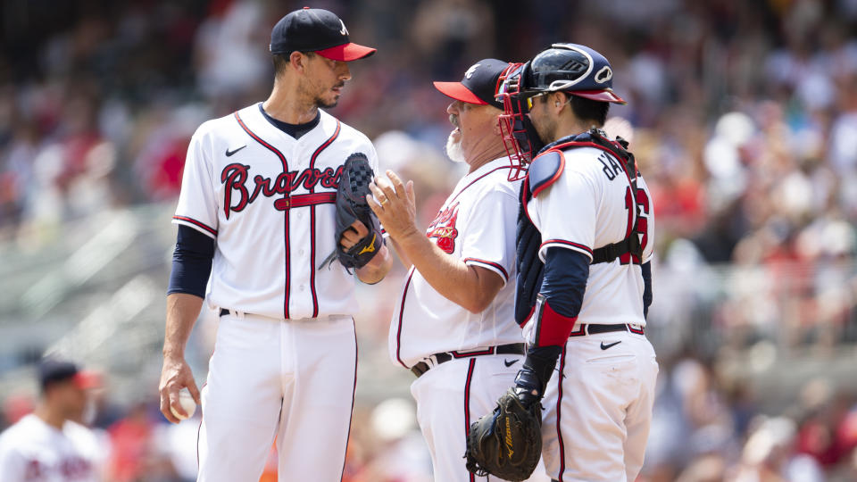 Atlanta Braves pitching coach Rick Kranitz, center, and catcher Travis d'Arnaud, right, speak with starting pitcher Charlie Morton, left, in the third inning of a baseball game against the Houston Astros, Sunday, Aug. 21, 2022, in Atlanta. (AP Photo/Hakim Wright Sr.)