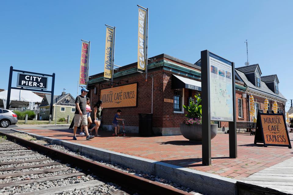 Customers walk past the newly opened Mirasol's Cafe Express at Pier 3 in New Bedford.