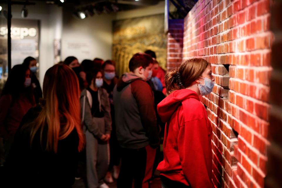 Students peer into an installation at the Holocaust & Humanity Center inside the Cincinnati Museum Center at Union Terminal.