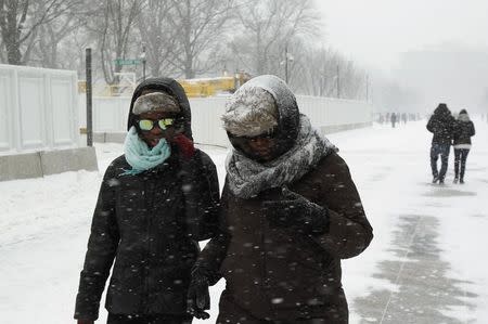 People walk under snow along Pennsylvania Avenue in Washington February 21, 2015. REUTERS/Yuri Gripas