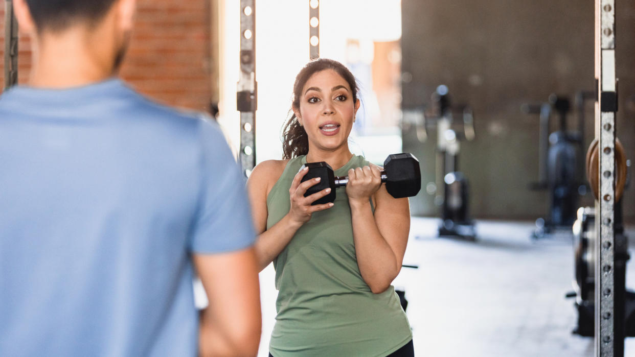  A trainer demonstrating a dumbbell exercise. 