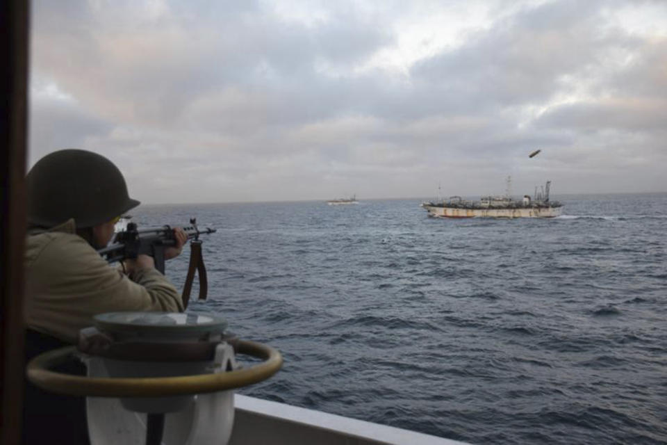 FILE - In this photo provided by Argentina's Coast Guard, a soldier fires at the Chinese fishing boat named Jing Yuan 626 in Argentine waters on Thursday, Feb. 22, 2018. The operation was called off by Argentina's foreign ministry after the vessel was chased for nearly eight hours, according to Argentina's prefecture. (Argentine Coast Guard via AP, File)