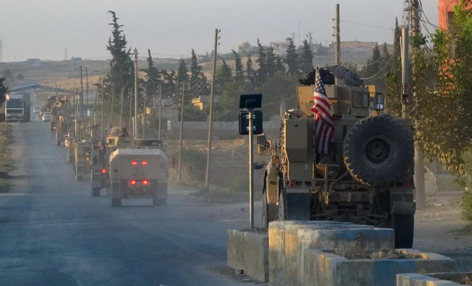 In this image provided by Hawar News Agency, ANHA, U.S. military vehicles travel down a main road in northeast Syria, Monday, Oct. 7, 2019. U.S.-backed Kurdish-led forces in Syria said American troops began withdrawing Monday from their positions along Turkey's border in northeastern Syria, ahead of an anticipated Turkish invasion that the Kurds say will overturn five years of achievements in the battle against the Islamic State group. (ANHA via AP)