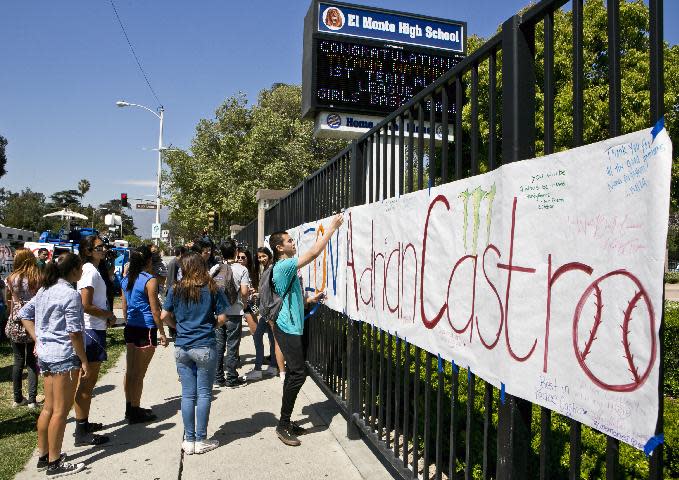 El Monte High School students hang a banner for senior Adrian Castro, outside El Monte High School in El Monte, Calif., Friday, April 11, 2014. Castro was killed when the Humboldt State University-bound bus he was on crashed in Orland on Thursday, an El Monte school official said. (AP Photo/Damian Dovarganes)