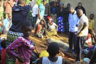 In this photo taken Friday, Oct 5, 2018, family members and onlookers mourn over bodies of civilians killed by The Allied Democratic Forces rebels in Beni, Eastern Congo. Congo’ military said Sunday Oct. 21, 2018, that rebels attacked an Ebola treatment centre in Beni, leaving over a dozen civilians dead and abducted about a dozen children, which could force crucial virus containment efforts to be suspended in the area. (AP Photo/Al-hadji Kudra Maliro)