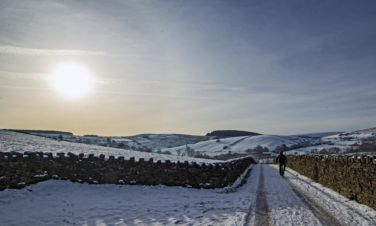 <p>A cyclist on the snow at Blackmoss Reservoir in Barley, Pendle, Lancashire.</p> (PA)