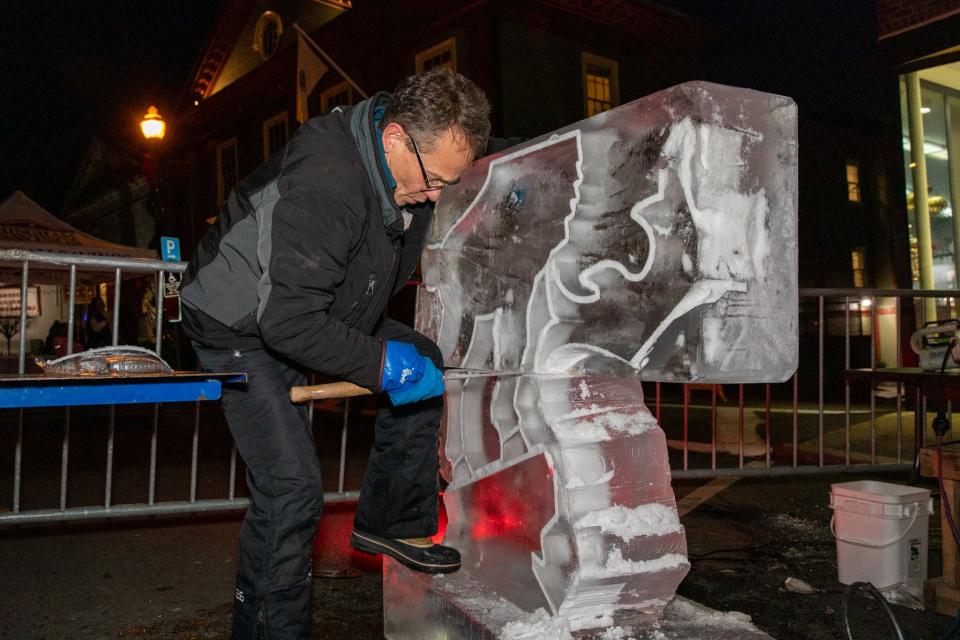 Donald Chapelle, of North Andover, uses an ice sculpting saw to add friction between two layers of ice during a live demonstration in Hingham on Friday, Dec. 2, 2022.