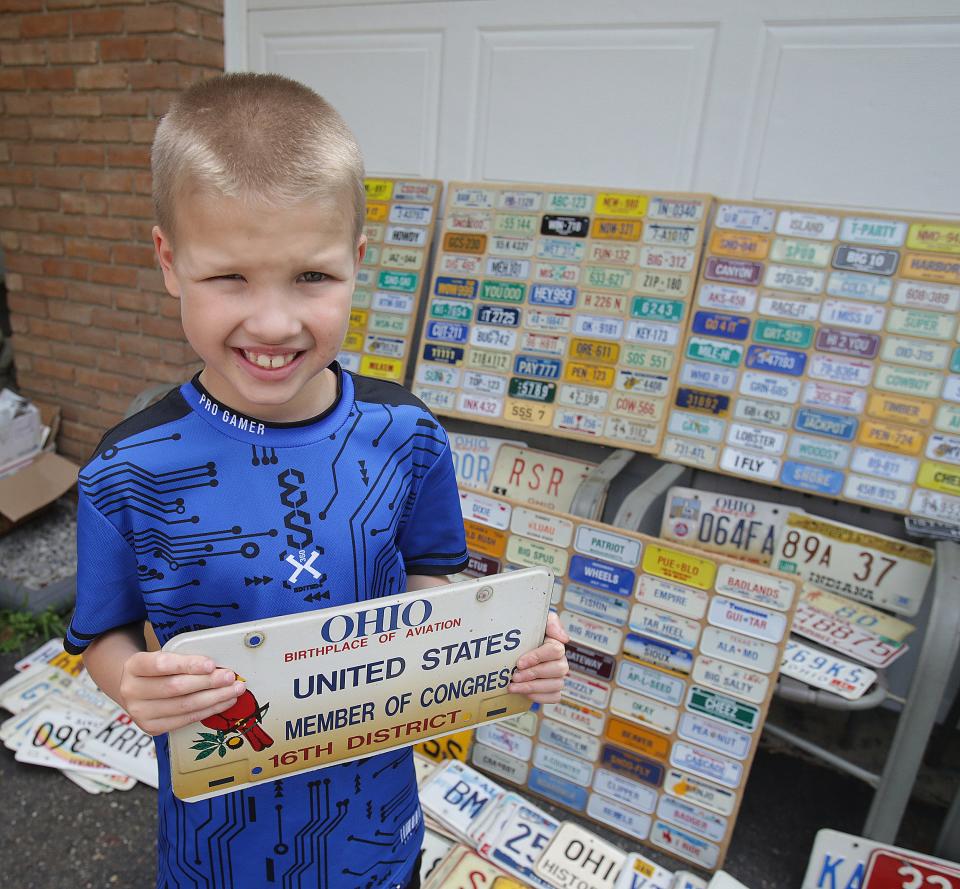 Luke Reicosky holds one of his new favorite Ohio license plates that he's recently received. Luke, 7, of Brewster collects license plates.