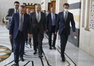 In this photo released on the official Facebook page of the Syrian Presidency, shows Syrian President Bashar Assad, right, wearing a mask to help prevent the spread of the coronavirus, walks with Russian Foreign Minister Sergey Lavrov, center, and Deputy Prime Minister Yuri Borisov, left, in Damascus, Syria, Monday, Sept. 7, 2020. Lavrov met with Syrian President Bashar Assad shortly after landing in the Syrian capital on his first visit since 2012. (Syrian Presidency via Facebook)