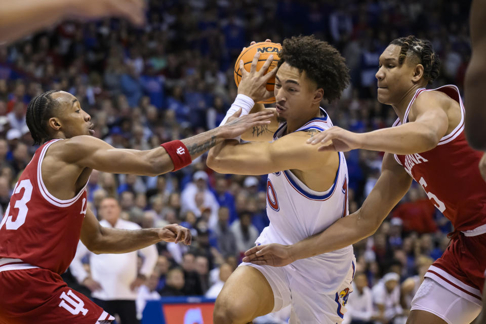 Kansas forward Jalen Wilson (10) drives between Indiana guard Tamar Bates (53) and forward Malik Reneau (5) during the first half of an NCAA college basketball game in Lawrence, Kan., Saturday, Dec. 17, 2022. (AP Photo/Reed Hoffmann)