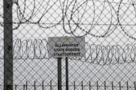 FILE - In this Monday, April 8, 2019 file photo, a sign reading: "State Border" is attached to a fence at Hungary's border with Serbia near the village Asotthalom, Hungary. When Hungary and Poland joined the European Union in 2004, after decades of Communist domination, they thirsted for Western democratic standards and prosperity yet, 17 years later, as the EU ramps up efforts to rein in democratic backsliding in both countries, some of the governing right-wing populists in Hungary and Poland are comparing the bloc to their former Soviet oppressors — and flirting with the prospect of exiting the bloc. (AP Photo/Darko Vojinovic, File)