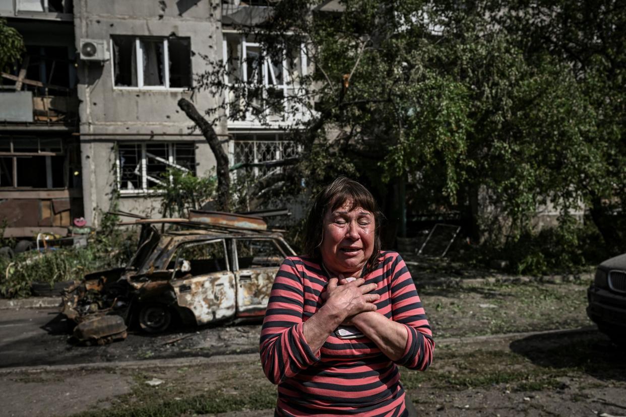Image: A woman cries outside a damaged apartment building after a strike in the city of Slovyansk at the eastern Ukrainian region of Donbas on May 31, 2022. (Aris Messinis / AFP - Getty Images)