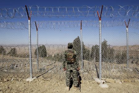 A soldier stands guard along the border fence at the Angoor Adda outpost on the border with Afghanistan in South Waziristan, Pakistan October 18, 2017. REUTERS/Caren Firouz