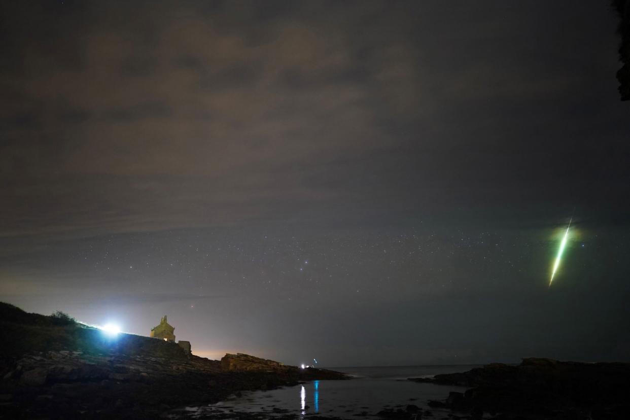 A fisherman watches a meteor during the Draconid meteor shower over Howick rocks in Northumberland. Picture date: Sunday October 10, 2021. (Photo by Owen Humphreys/PA Images via Getty Images)