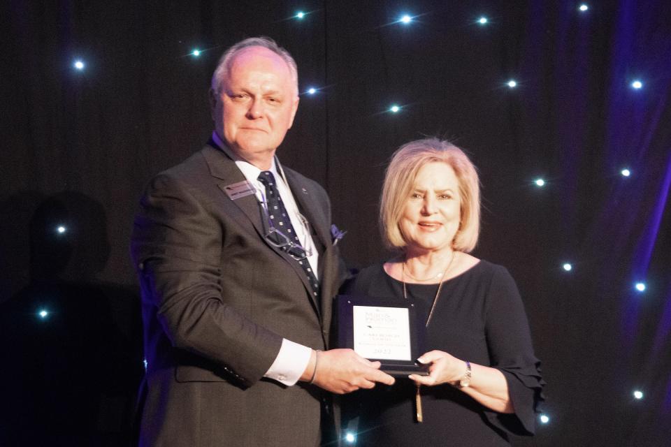 Andy Marshall, Chief Executive Officer and President of First Bank Southwest, presents Cari Roach Good with the 2022 AGN Woman of the Year award at the awards luncheon Wednesday at the Amarillo Civic Center.