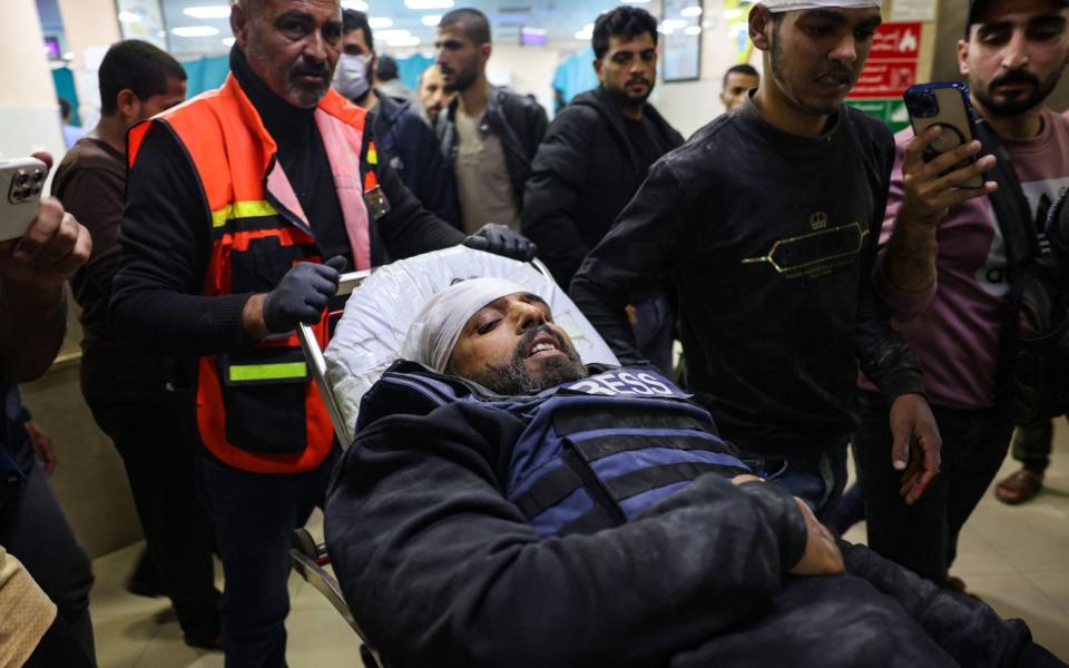 Reuters news agency cameraman Fadi Shanna arrives at a hospital after being injured while filming the destruction of a house in Khan Yunis