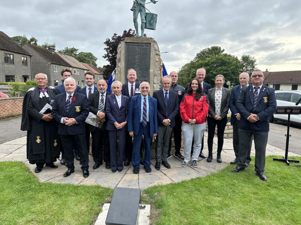 Willie Thornton's daughter Lynn joins legendary Rangers winger Willie Henderson in front of the war memorial in Winchburgh, West Lothian. Grandsons Colin and Iain are on the left of the back row. (Photo: ASA Scotland)