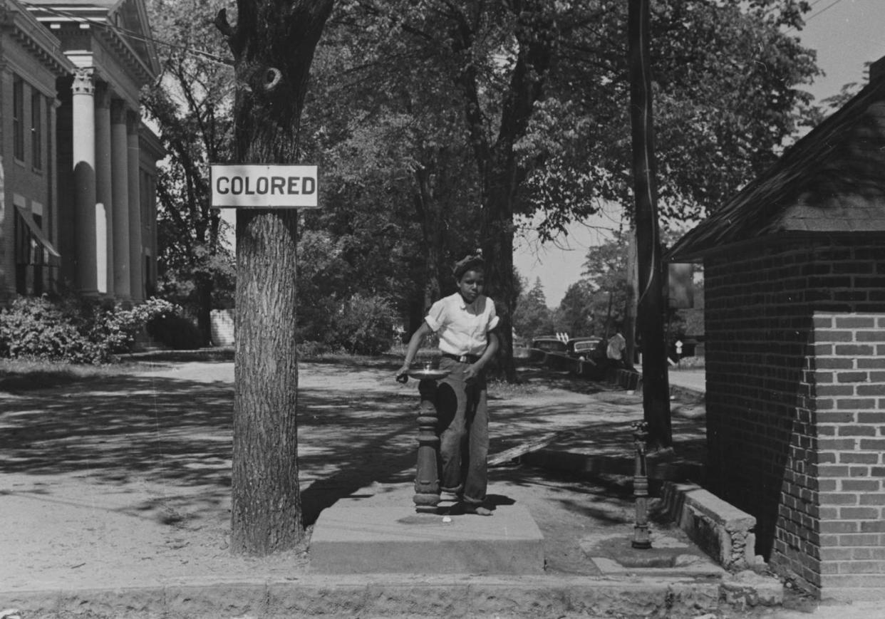 In this 1938 image, a Black boy uses a fountain marked 'colored' at a North Carolina county courthouse. <a href="https://www.gettyimages.com/detail/news-photo/photograph-of-an-african-american-child-using-a-water-news-photo/532291108?adppopup=true" rel="nofollow noopener" target="_blank" data-ylk="slk:Getty Images;elm:context_link;itc:0;sec:content-canvas" class="link ">Getty Images</a>