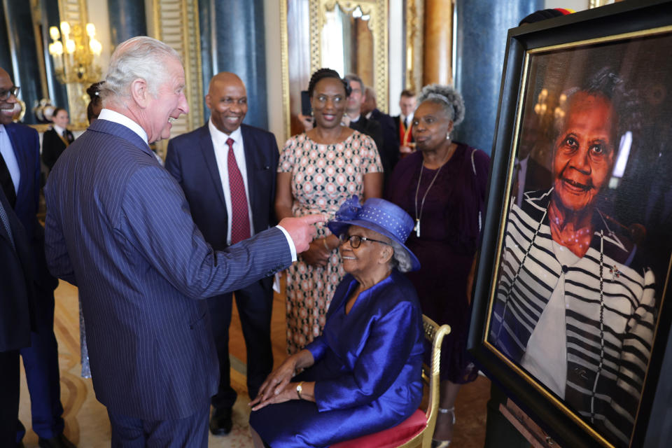 Britain's King Charles III (R) speaks with Gilda Oliver, alongside a portrait of them, during a reception to celebrate the Windrush Generation and mark the 75th anniversary of the arrival of the HMT Empire Windrush, at Buckingham Palace, in London, on June 14, 2023. During the reception, ten portraits of Windrush elders were unveiled. (Photo by Chris Jackson / POOL / AFP) (Photo by CHRIS JACKSON/POOL/AFP via Getty Images)