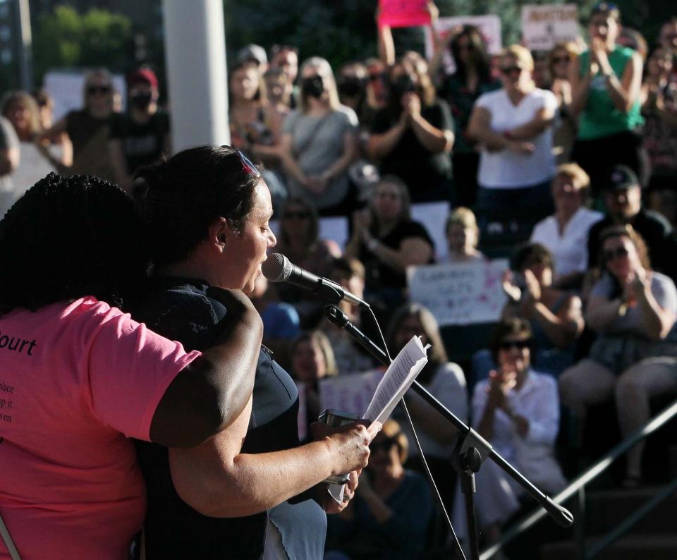 Kenyona Sunny Matthews, left, comforts Alecia Coco, a Cuyahoga Falls School Board member and mother of four children as Coco tells her experience of choosing to have an abortion as she speaks during the Rally for Reproductive Justice at the Cuyahoga Falls Pavilion and Amphitheater on Tuesday.