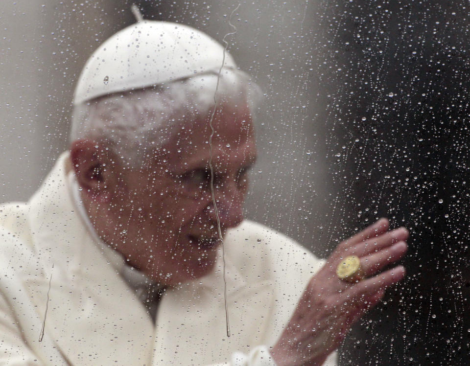 Pope Benedict XVI is seen behind a window covered in raindrops as he delivers his blessing from his pope-mobile in St. Peter's Square at the end of his general audience, at the Vatican, Wednesday, Oct. 31, 2012. (AP Photo/Gregorio Borgia)