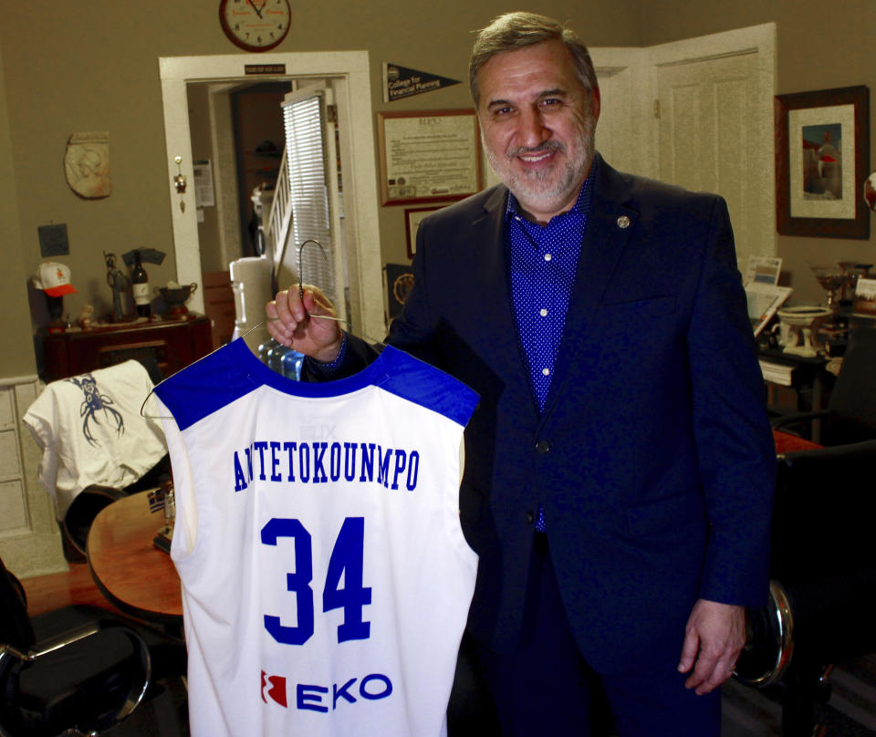 In this May 8, 2019 photo, Tim Stasinoulias, local president of the American Hellenic Educational Progressive Association, holds a Greek national basketball team jersey with Giannis Antetokuonmpo's name on it at his office in Hartland, Wis. The standout power forward of the Milwaukee Bucks has been a source of pride for the Greek community. The Milwaukee Bucks' championship run has the city buzzing with anticipation that the team has a chance to win their first title since 1971. (AP Photo/Carrie Antlfinger)