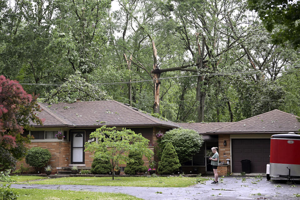 Sheri Redd stands in her driveway as fallen trees surround her home after a tornado struck the area in Livonia, Mich., Wednesday, June 5, 2024. (Robin Buckson/Detroit News via AP)